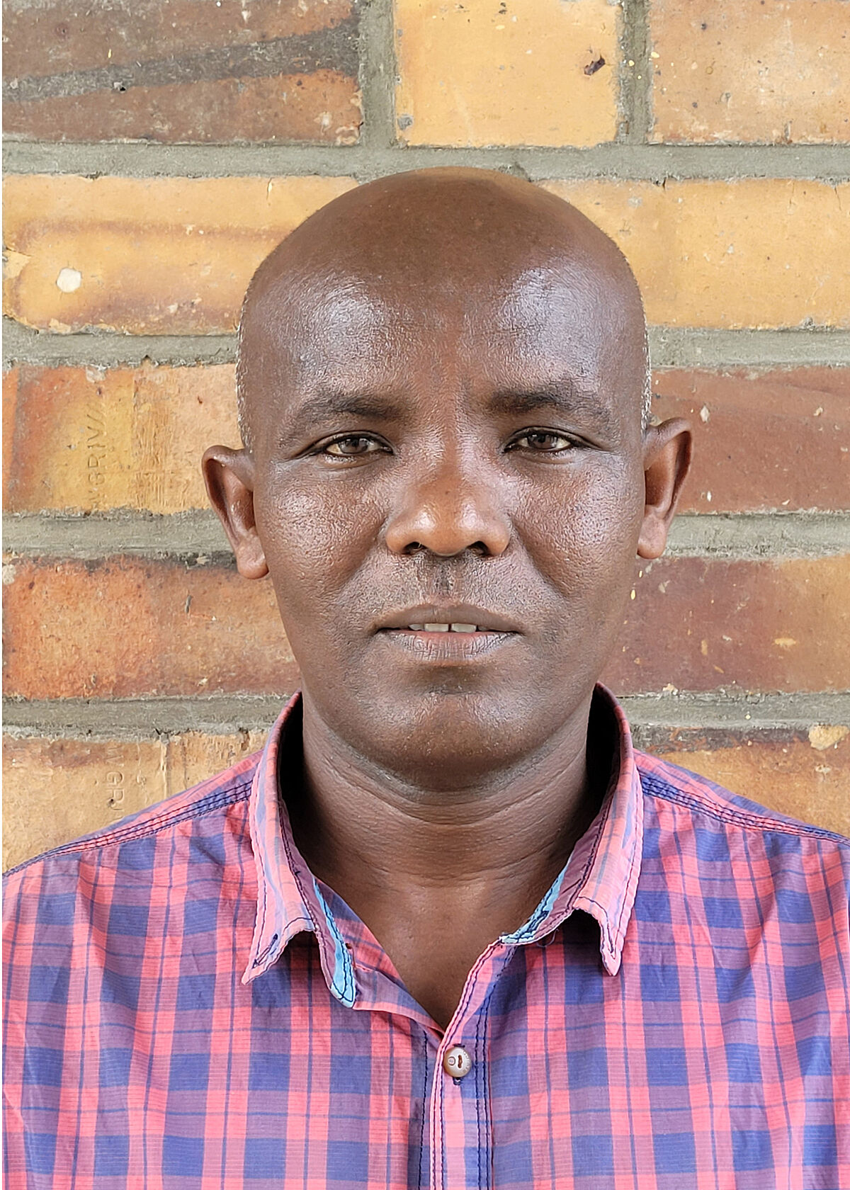 Portrait Amsalu Fite Tilahun in front of a stone wall