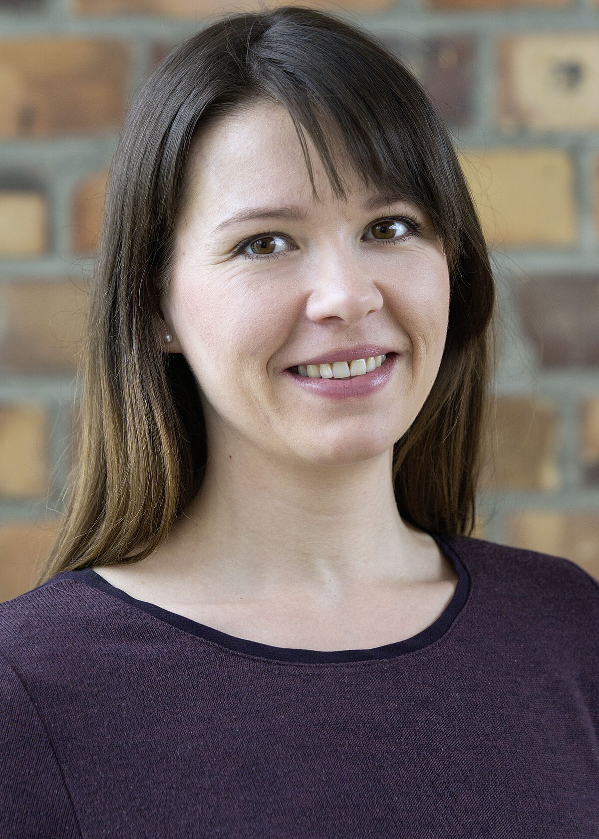 Portrait Julia Fallis in front of a stone wall