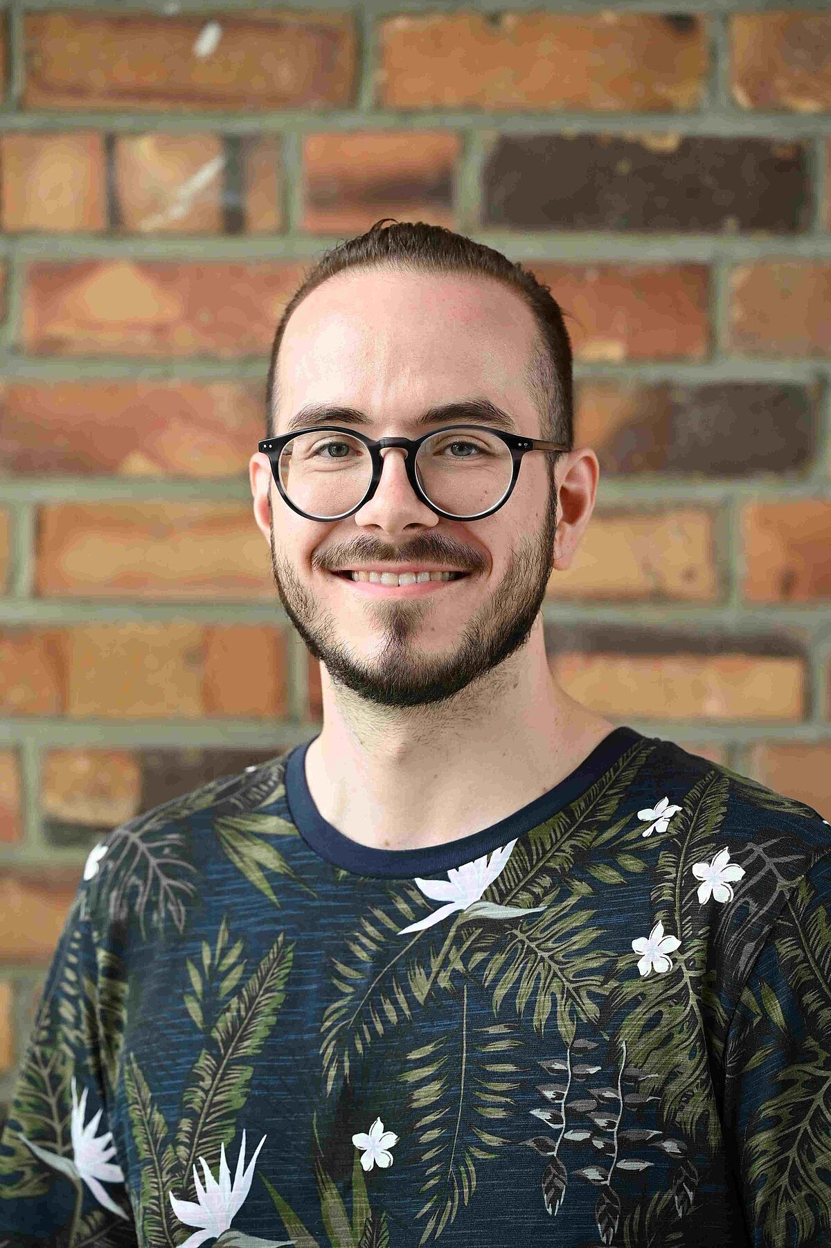 Portrait of Dominik Nemitz in front of a brickwall
