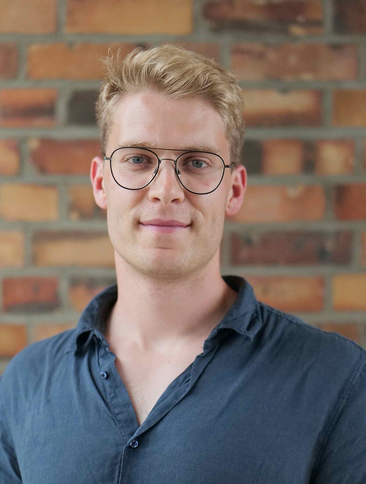 Portrait of Jakob Tornier in front of a brickwall