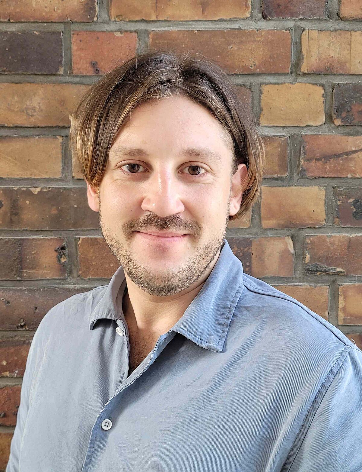 Portrait Maxim Schunevitsch vor einer Steinwand