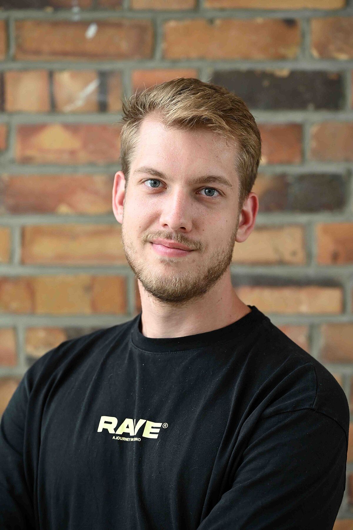 Portrait of Danny Franz in front of the background of a stone wall
