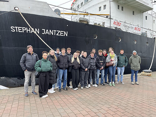 Die Schülergruppe aus Brunsbüttel vor dem historischen Eisbrecher Stephan Jantzen in Rostock – ein Highlight ihrer Exkursion, bei dem sie hautnah erleben konnten, wie Ingenieurwissenschaften in der Praxis angewendet werden. (Foto: Matthias Witte).