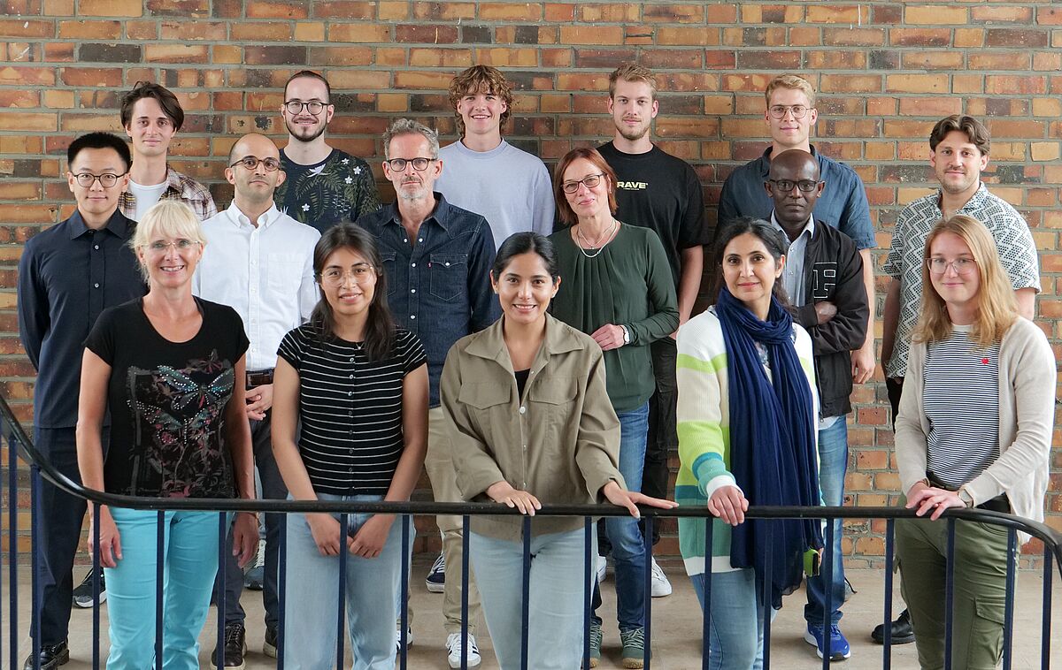 Staff members of the Department of Agronomy in front of a brick wall in the faculty building