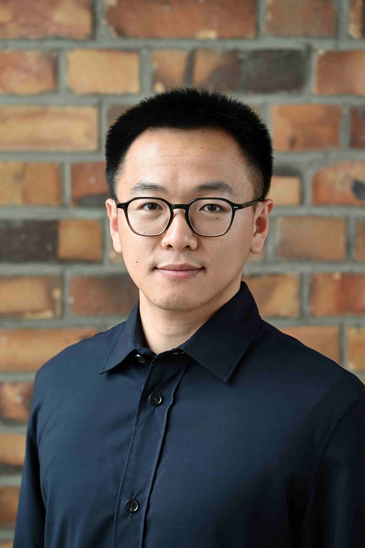 Portrait Yue Hu in front of a stone wall