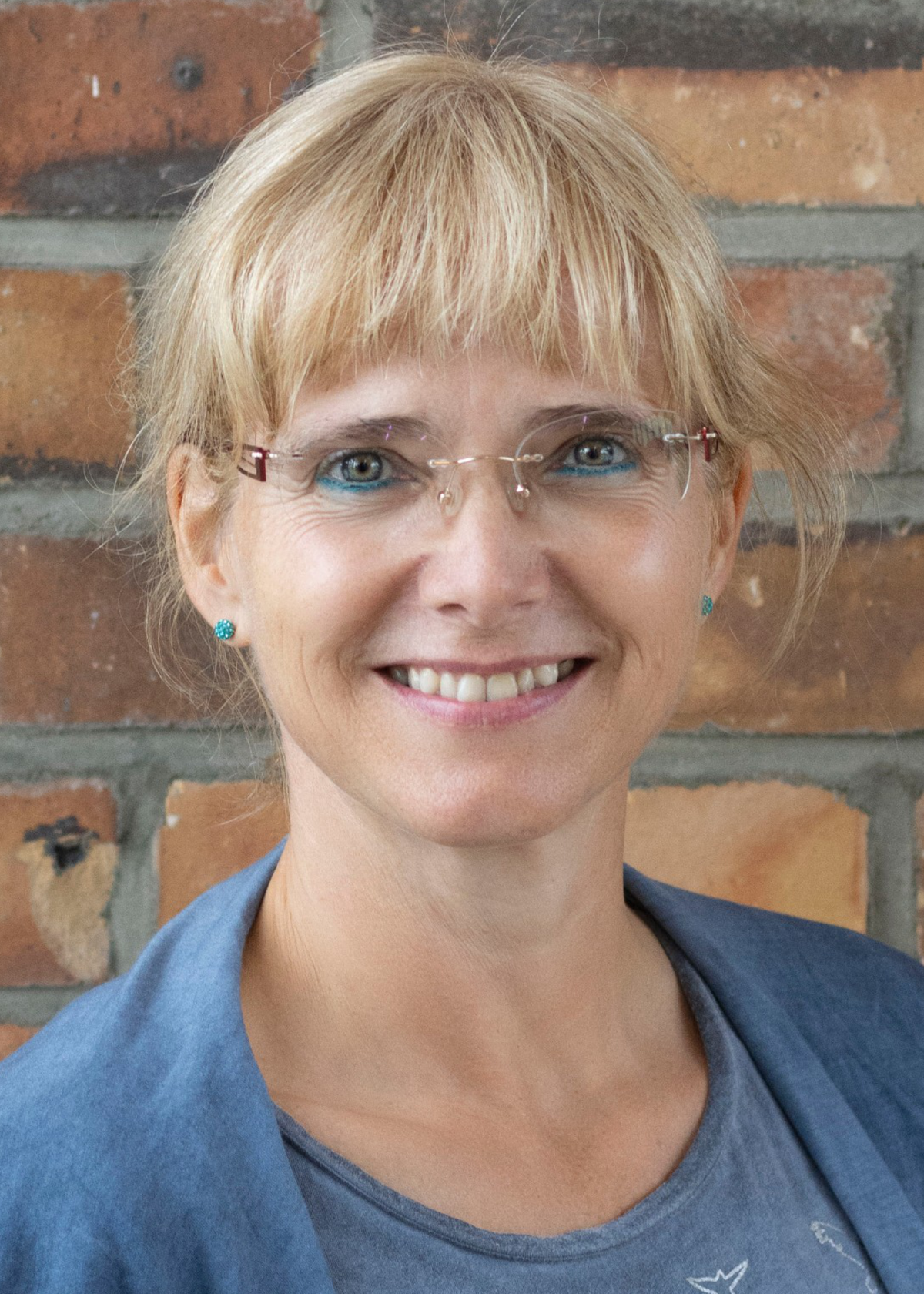 Portrait Uta Deiß in front of a stone wall