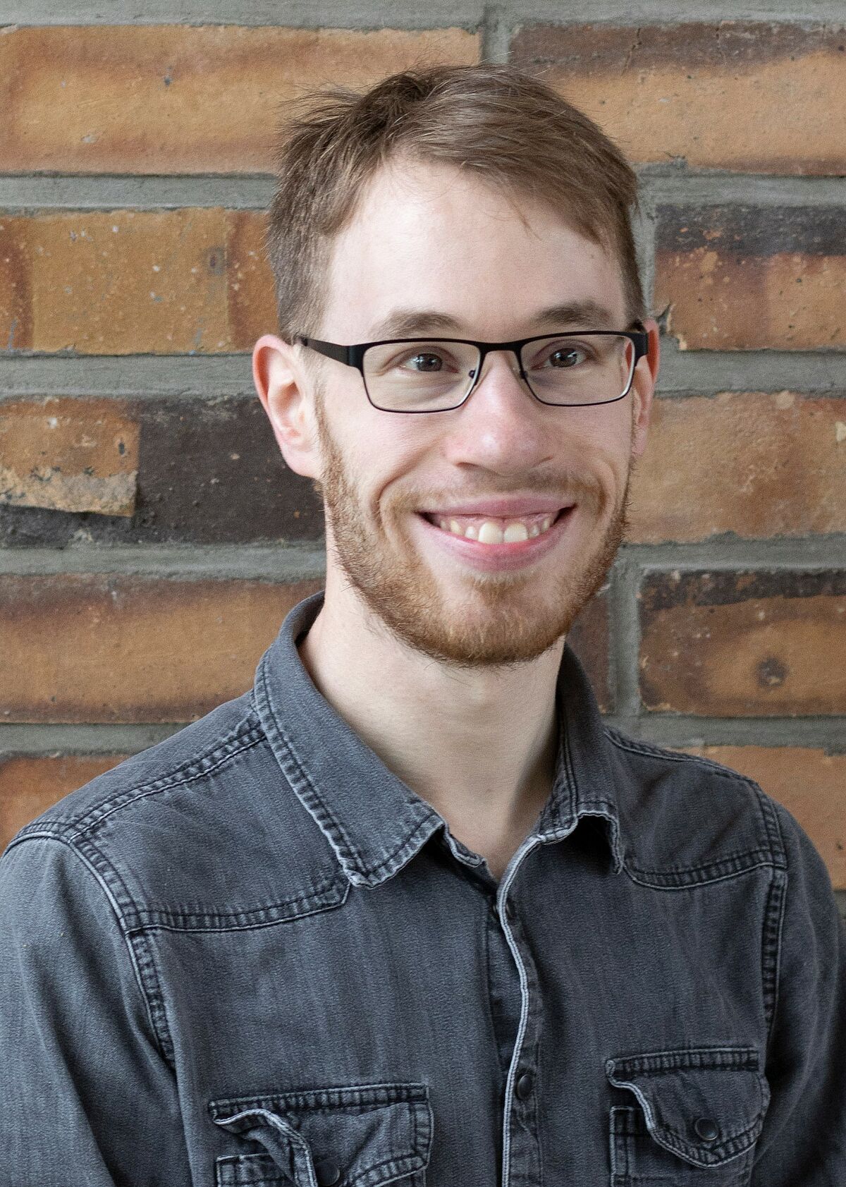 Portrait Julian Kirchgesser in front of a stone wall