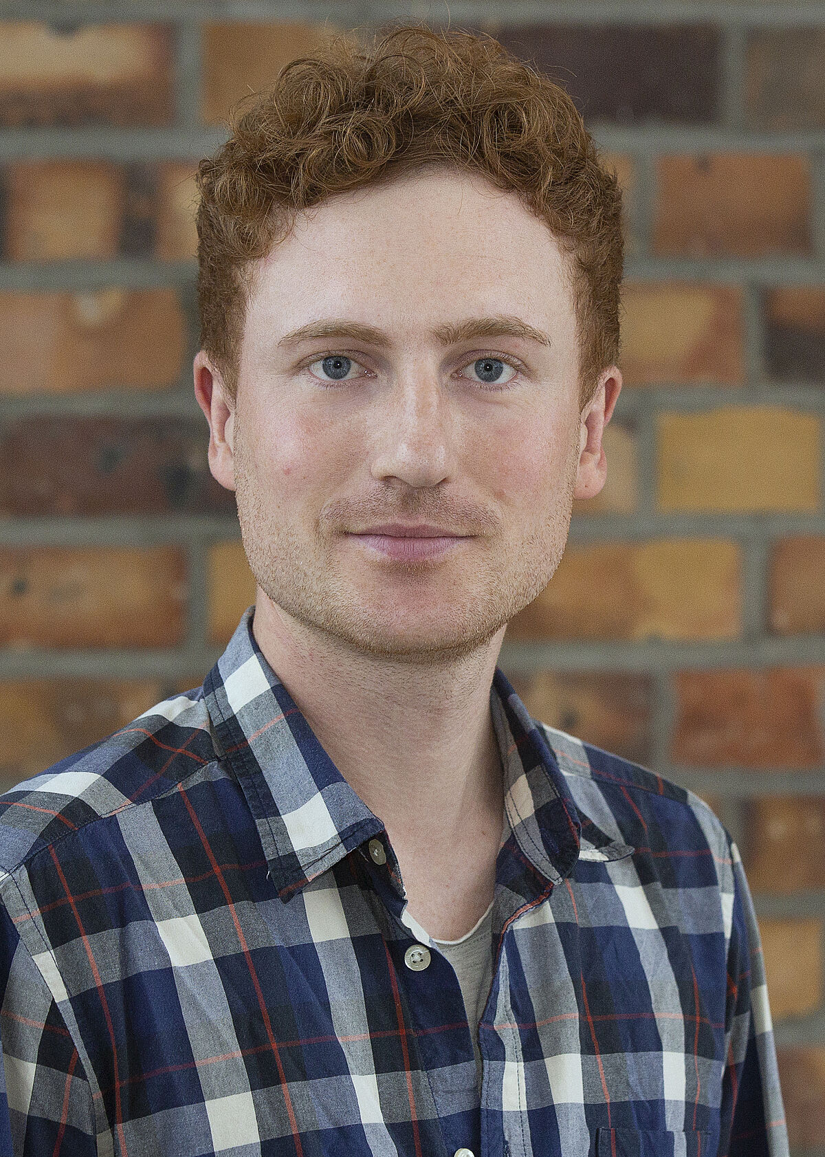 Portrait Marcel Ackermann vor einer Steinwand