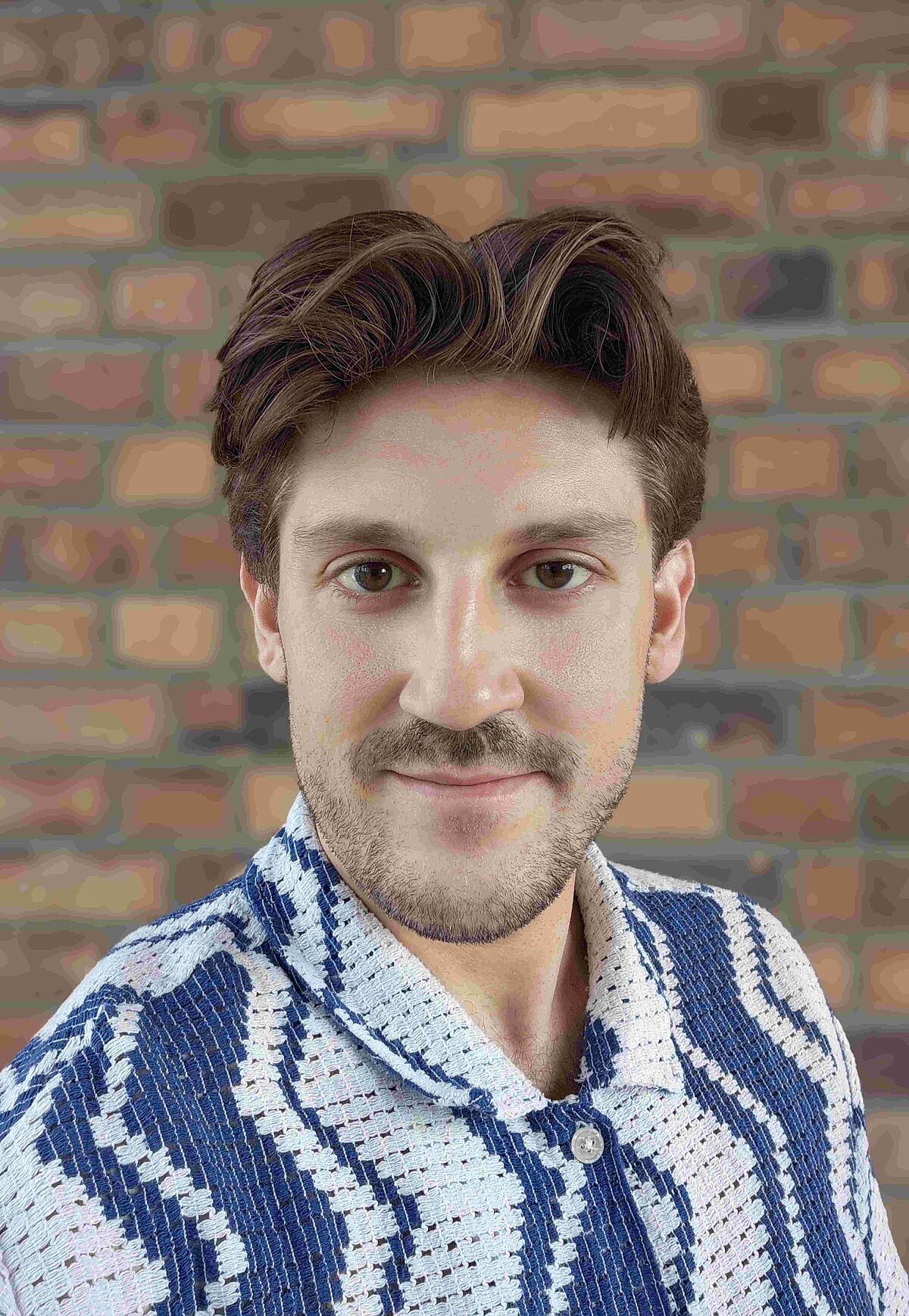 Portrait of Maxim Schunevitsch in front of a brickwall